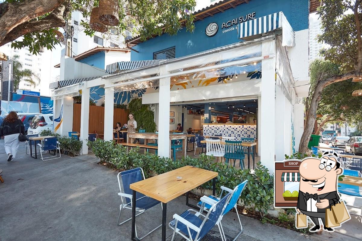 Fachada azul do Açaí Surf em Perdizes, com mesas e cadeiras na área externa